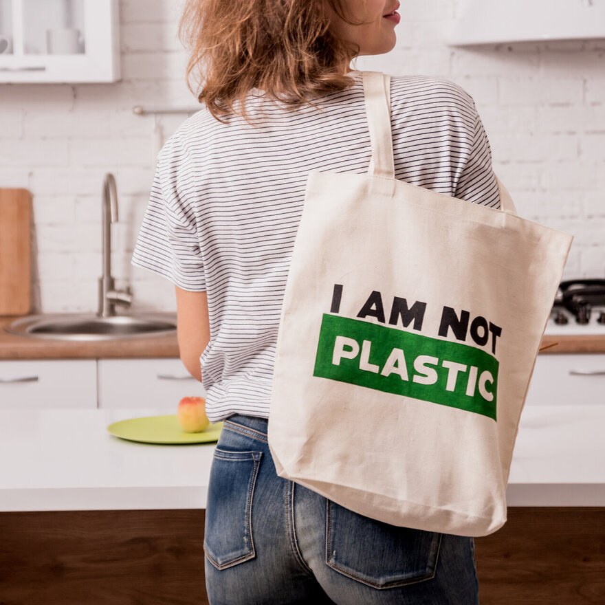 Young girl holding a cloth bag. At the kitchen. I am not plastic