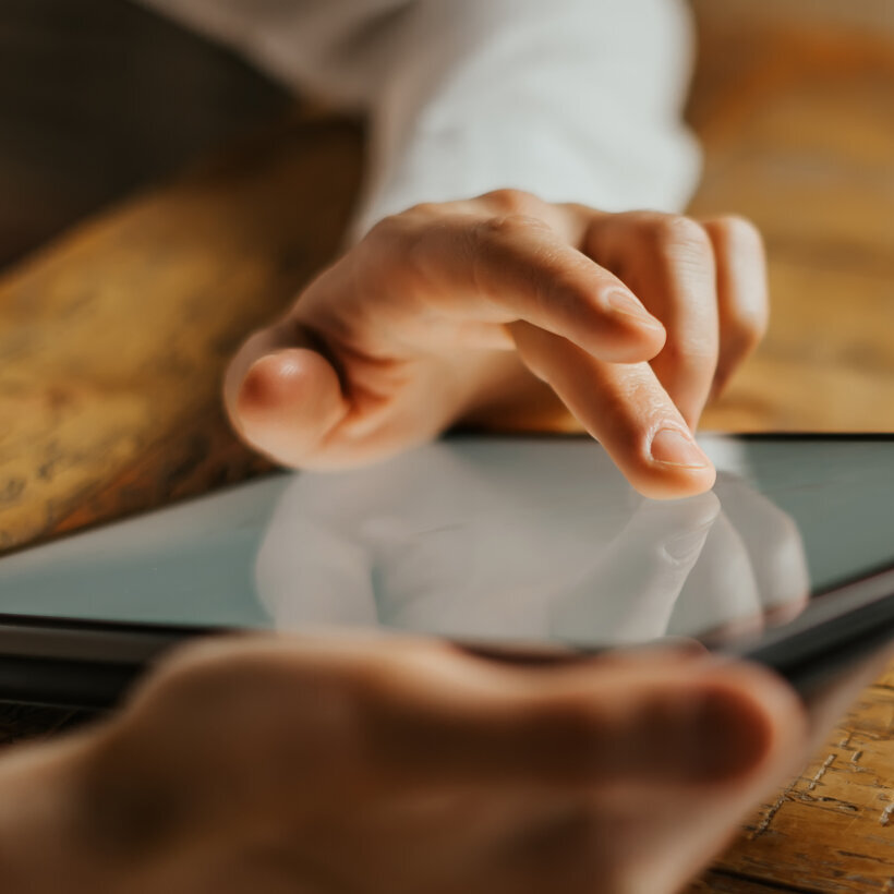 Male hands tapping on digital tablet screen. Close-up photo