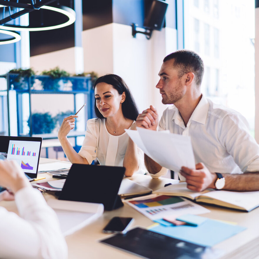 Insightful multiracial office workers analysing statistics and u