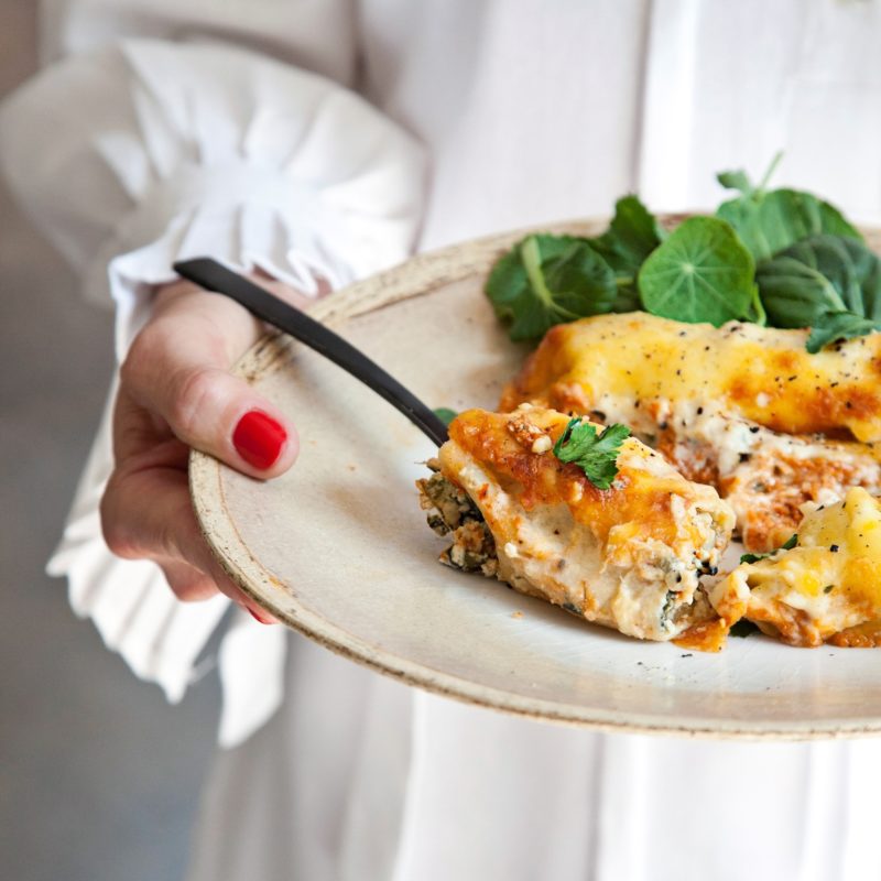 Eine Frau hält einen Teller voller Essen in der Hand.